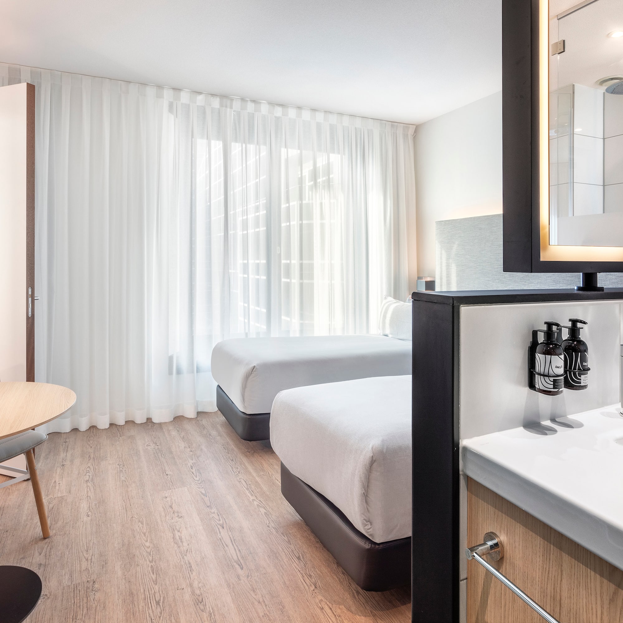 a room with two beds and a mirror