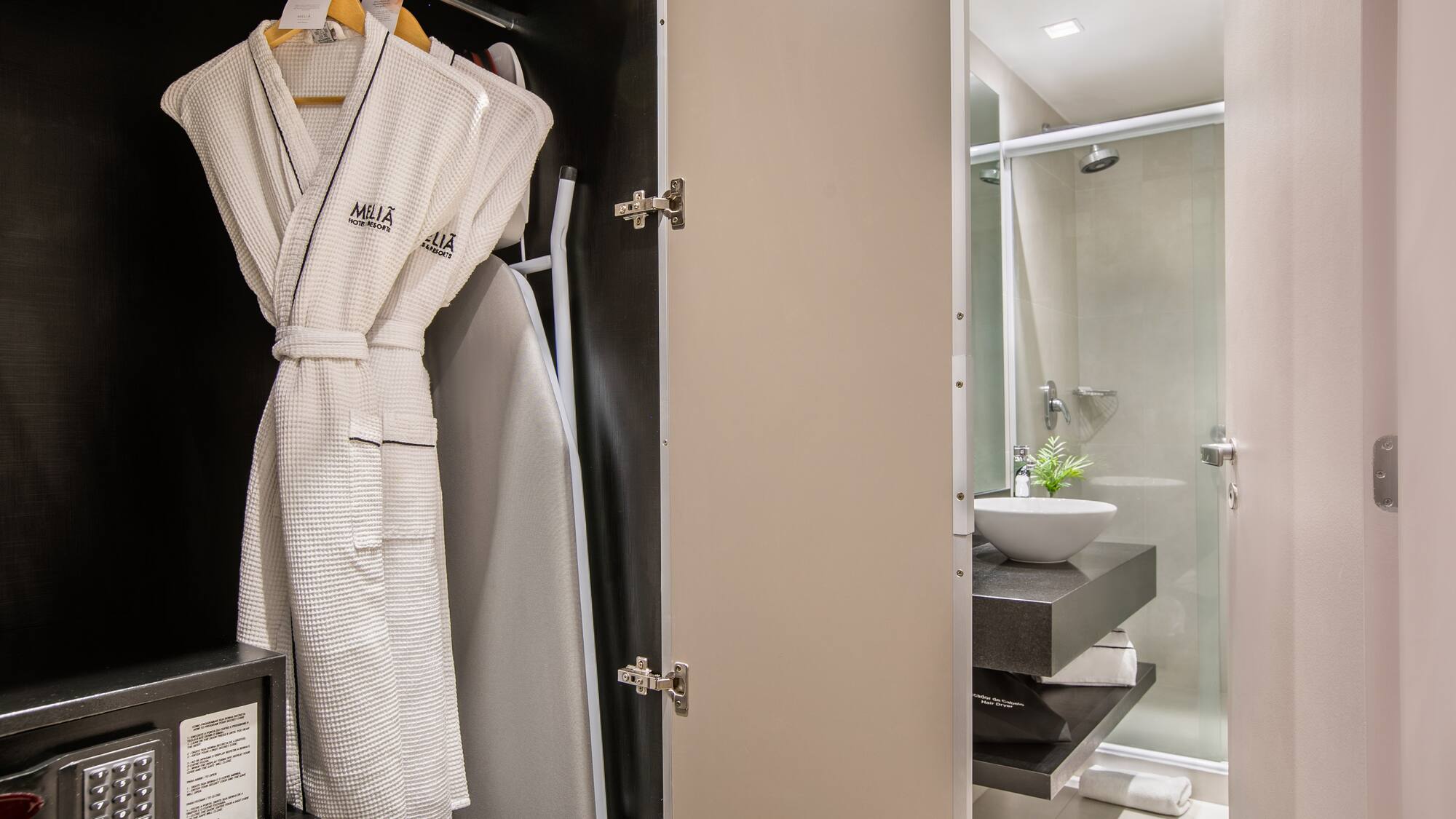 a bathroom with a white robe on a swinger
