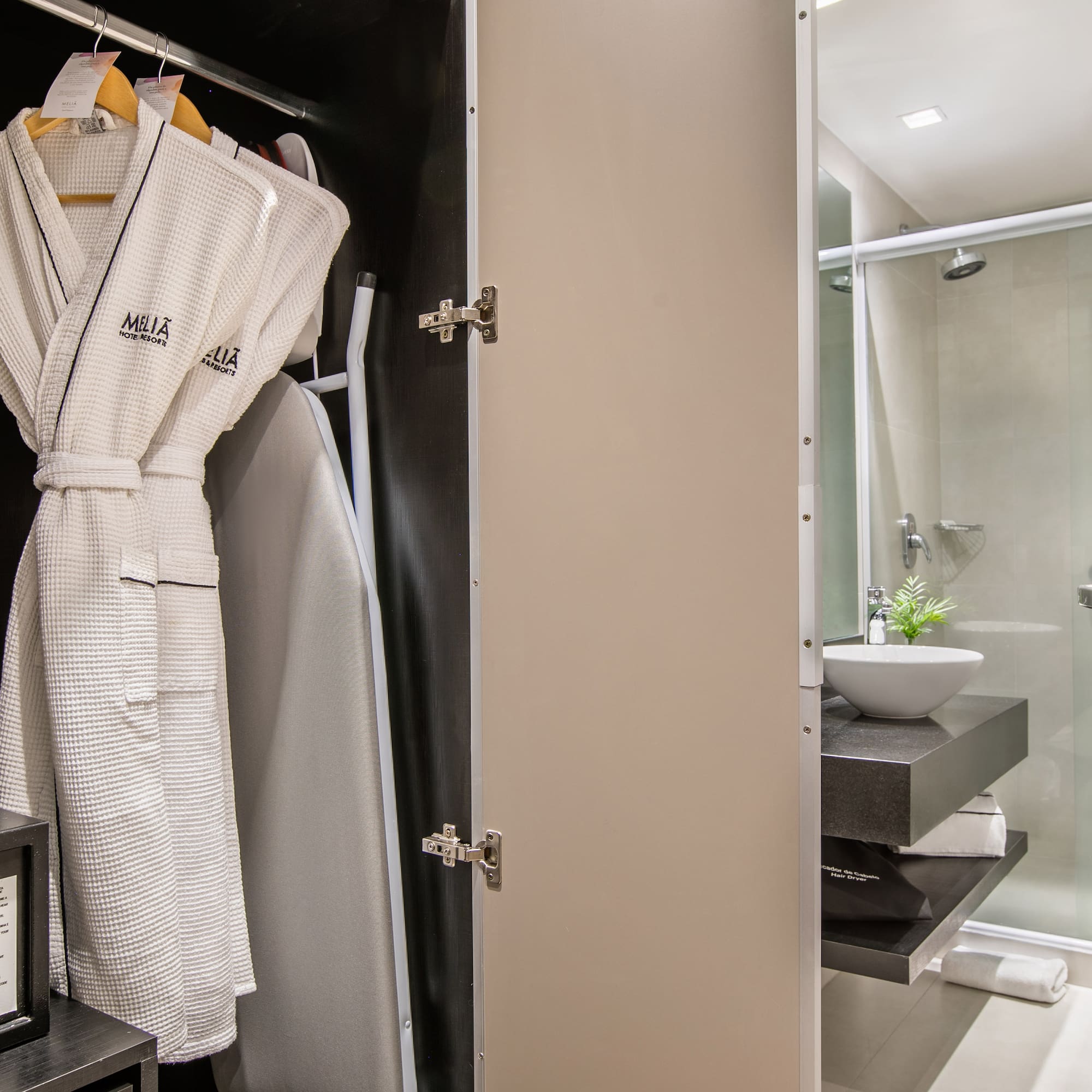 a bathroom with a white robe on a swinger