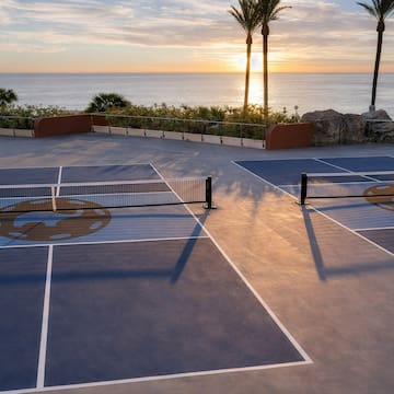 a tennis court with a view of the ocean