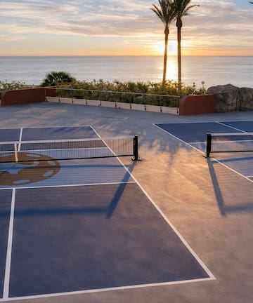 a tennis court with a view of the ocean