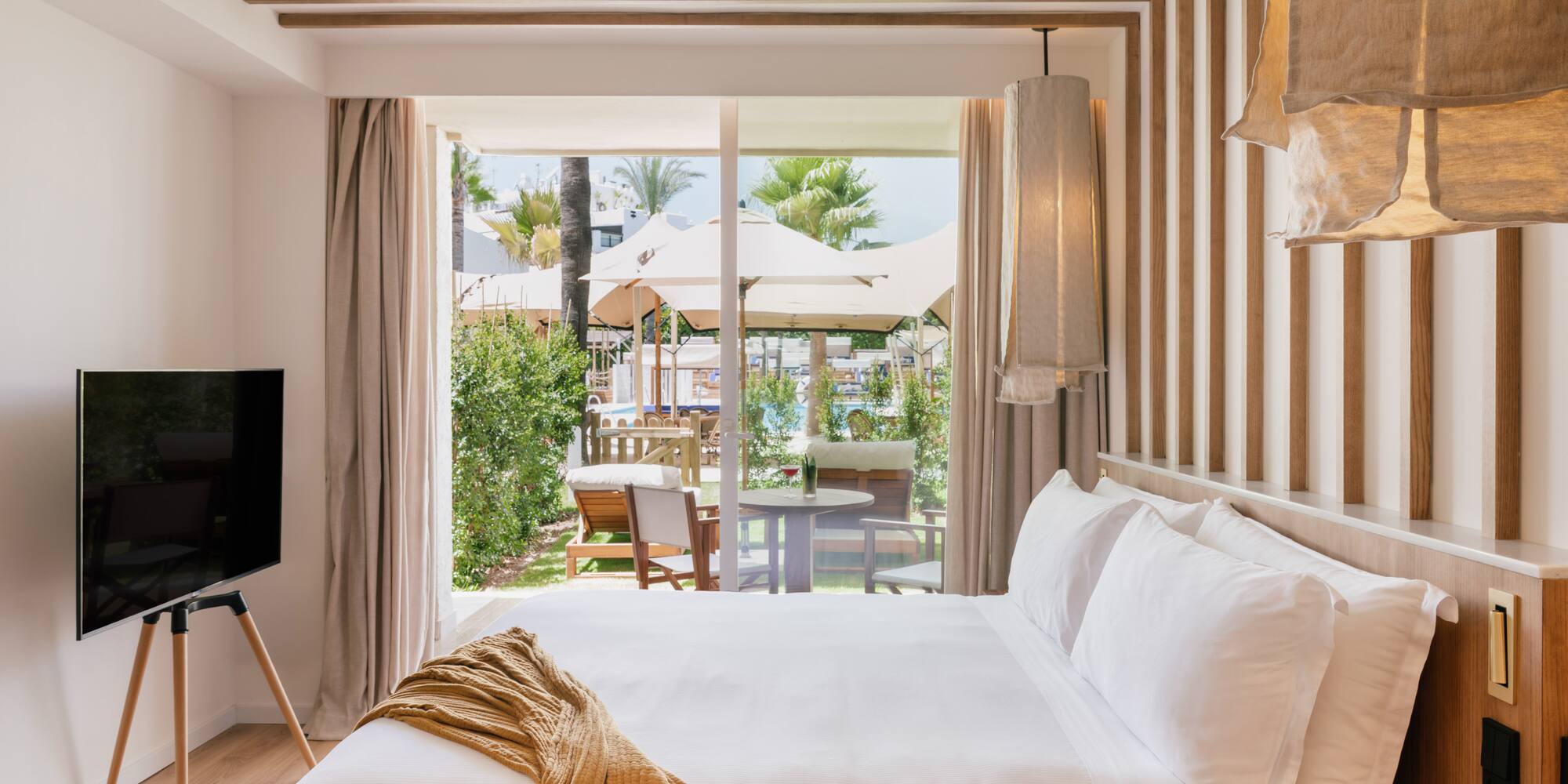 a bed with a television in a room with a view of the outside