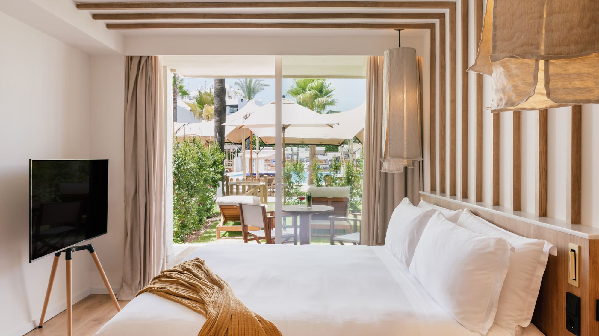 a bed with a television in a room with a view of the outside