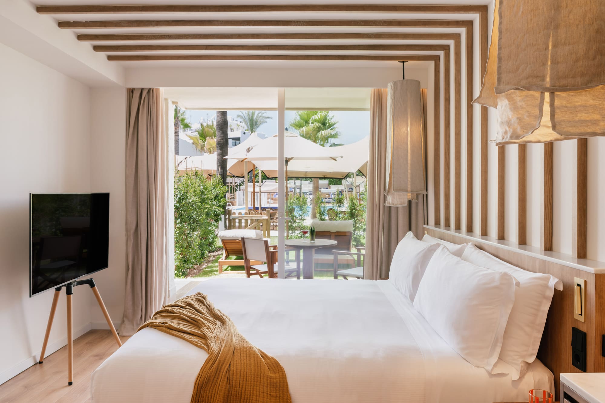 a bed with a television in a room with a view of the outside