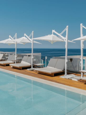 a pool with lounge chairs and umbrellas