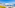 Sunny beach with white umbrellas, sun loungers, yellow flowers, blue ocean.