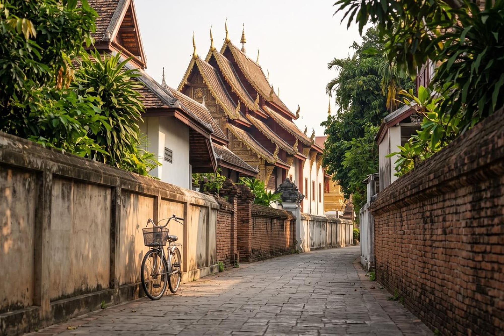 Bicycle on a paved Thai street with traditional temple architecture and walls.