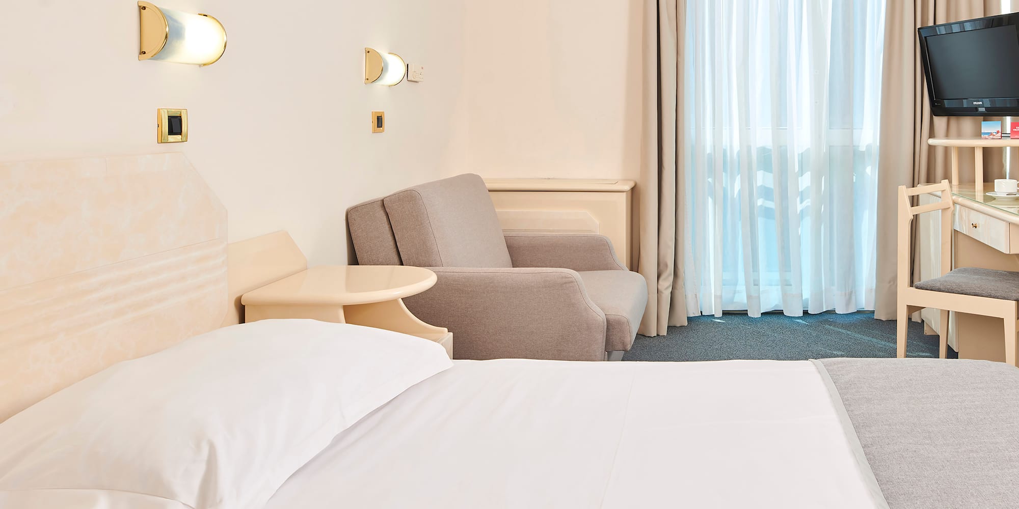 a bed and chair in a hotel room