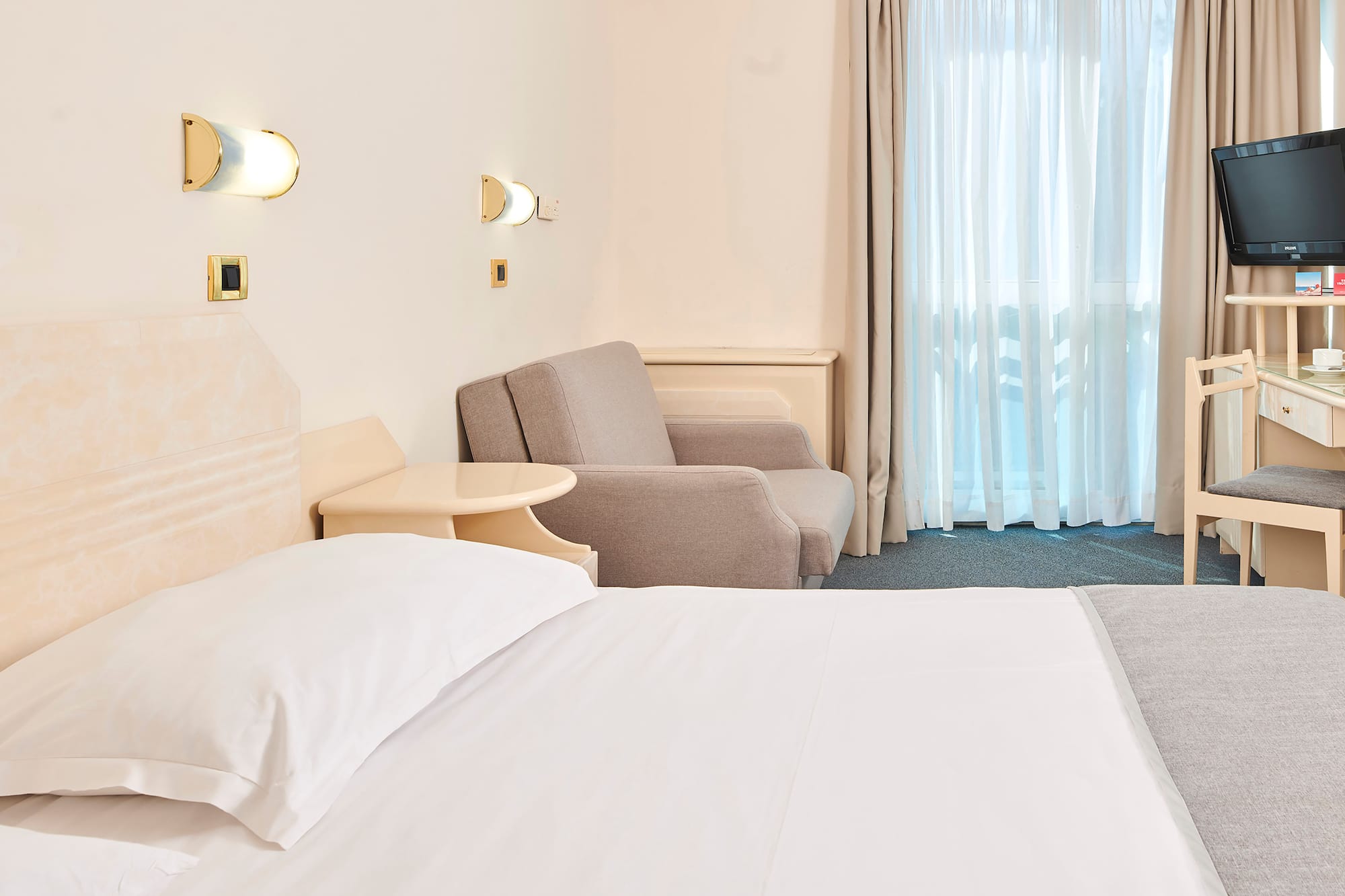 a bed and chair in a hotel room