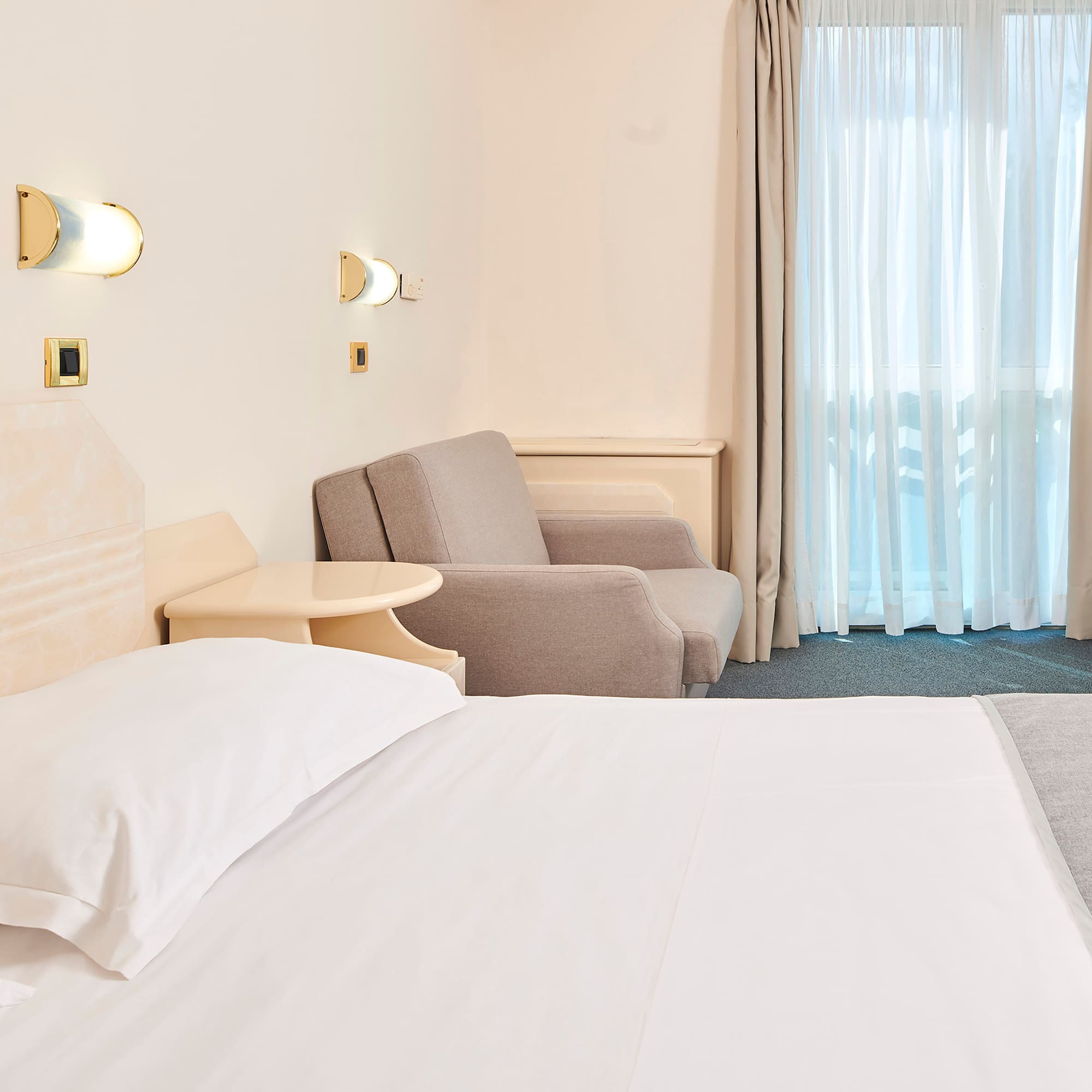 a bed and chair in a hotel room