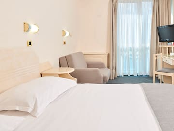 a bed and chair in a hotel room