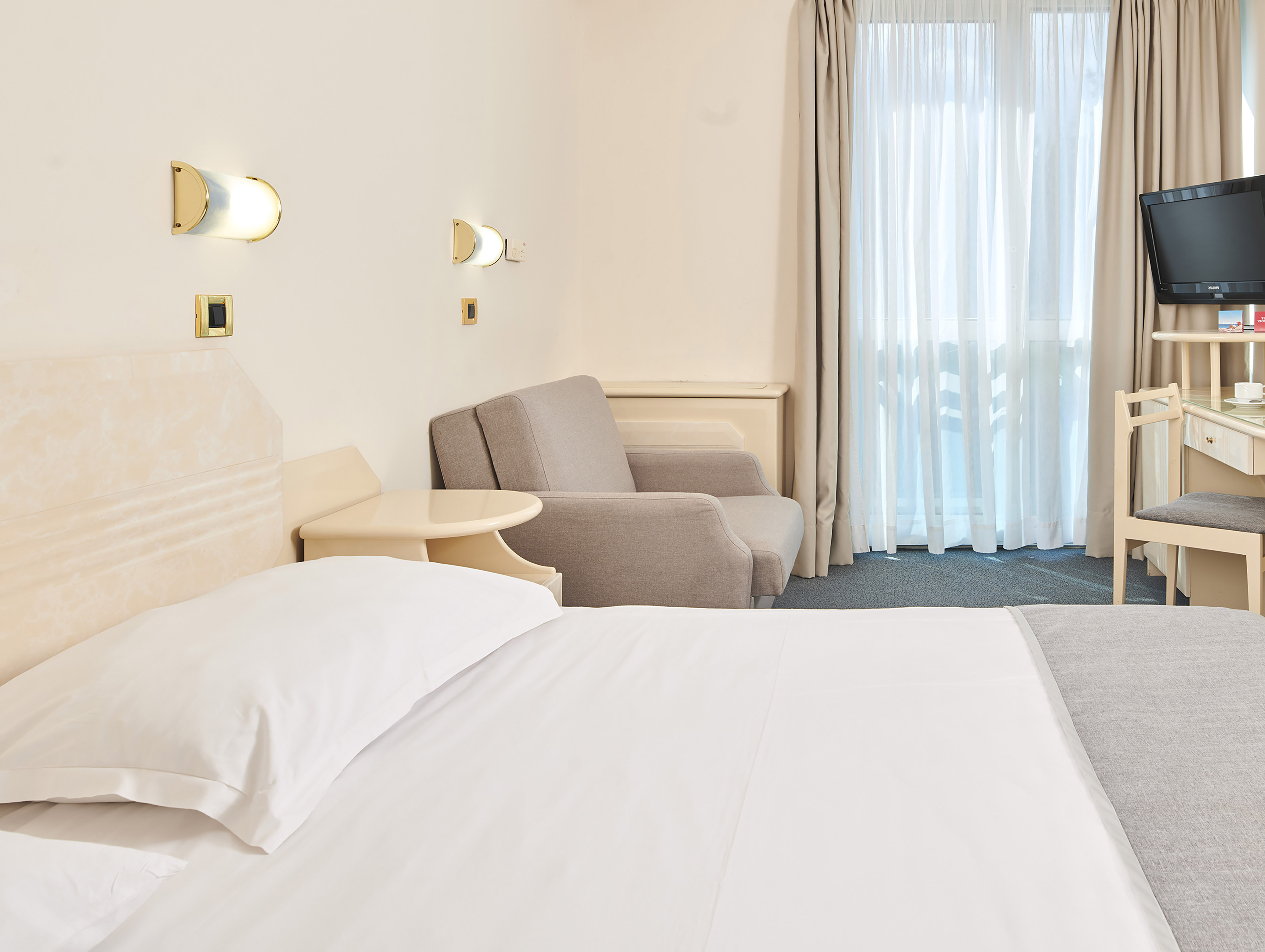a bed and chair in a hotel room
