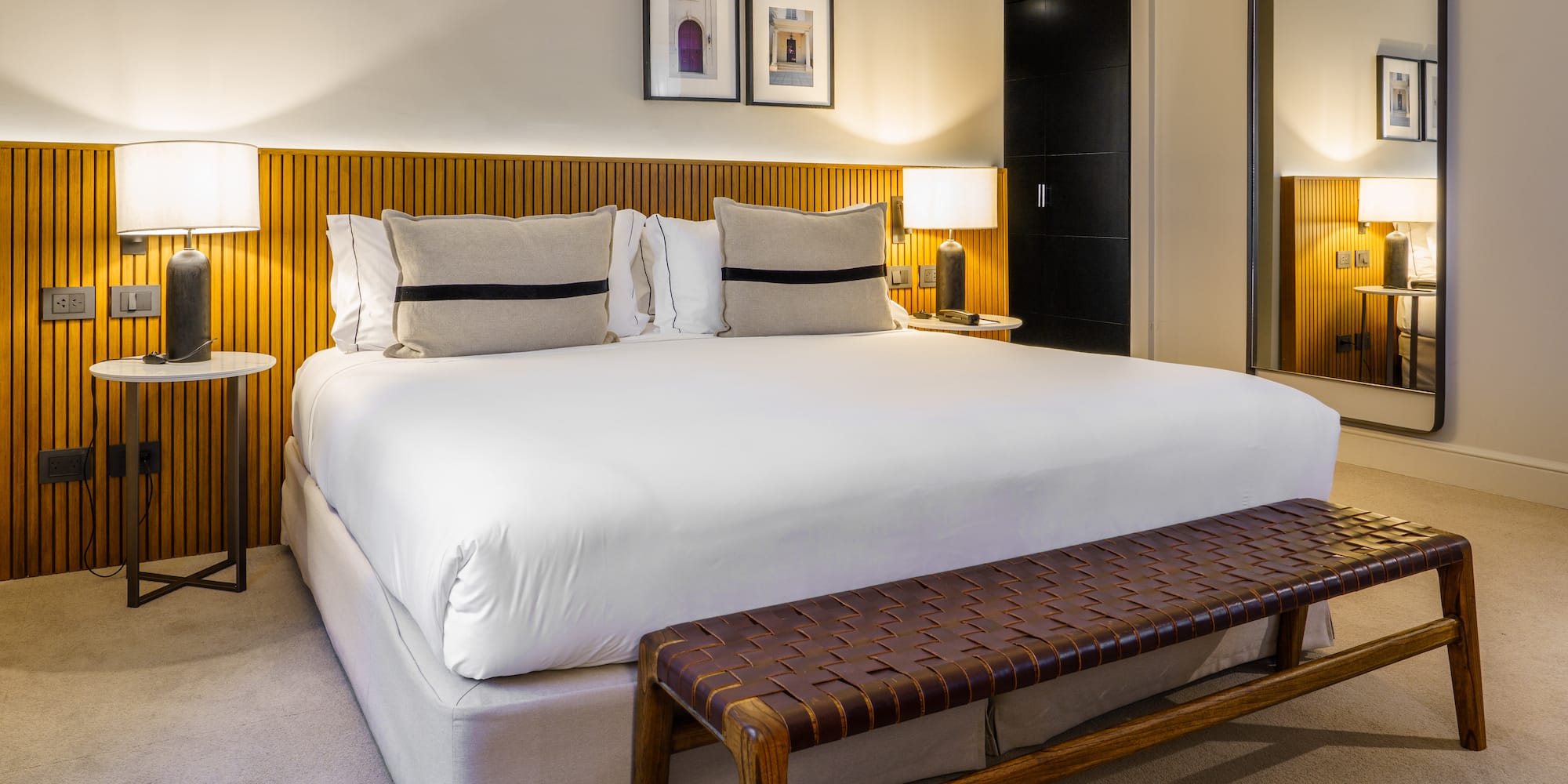 a bed with a bench and lamps