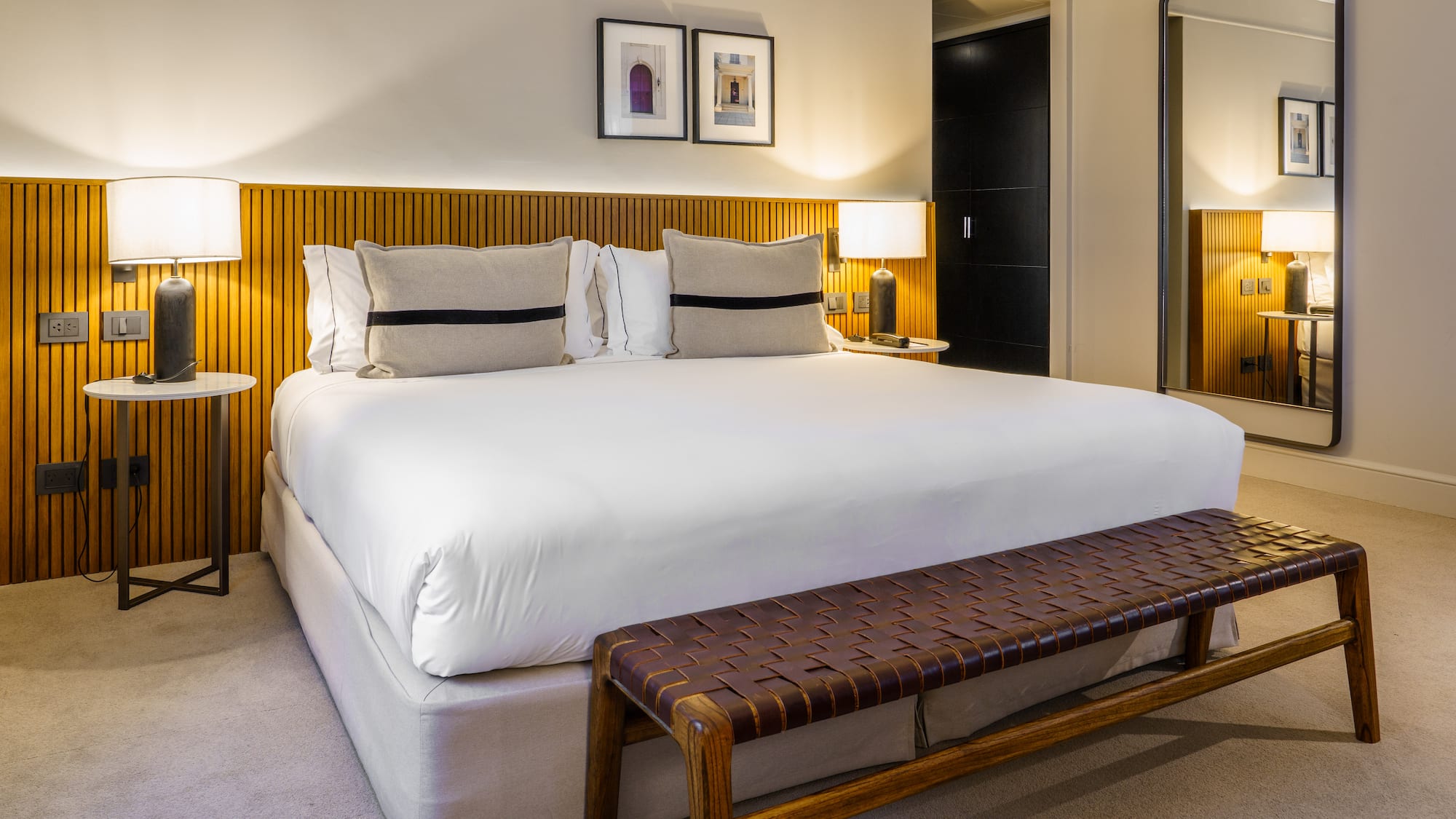 a bed with a bench and lamps