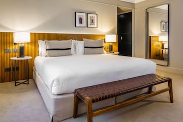 a bed with a bench and lamps