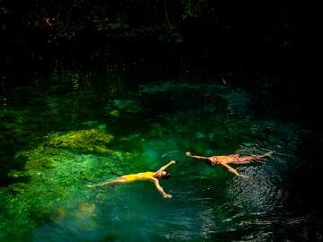 a couple of people swimming in a body of water