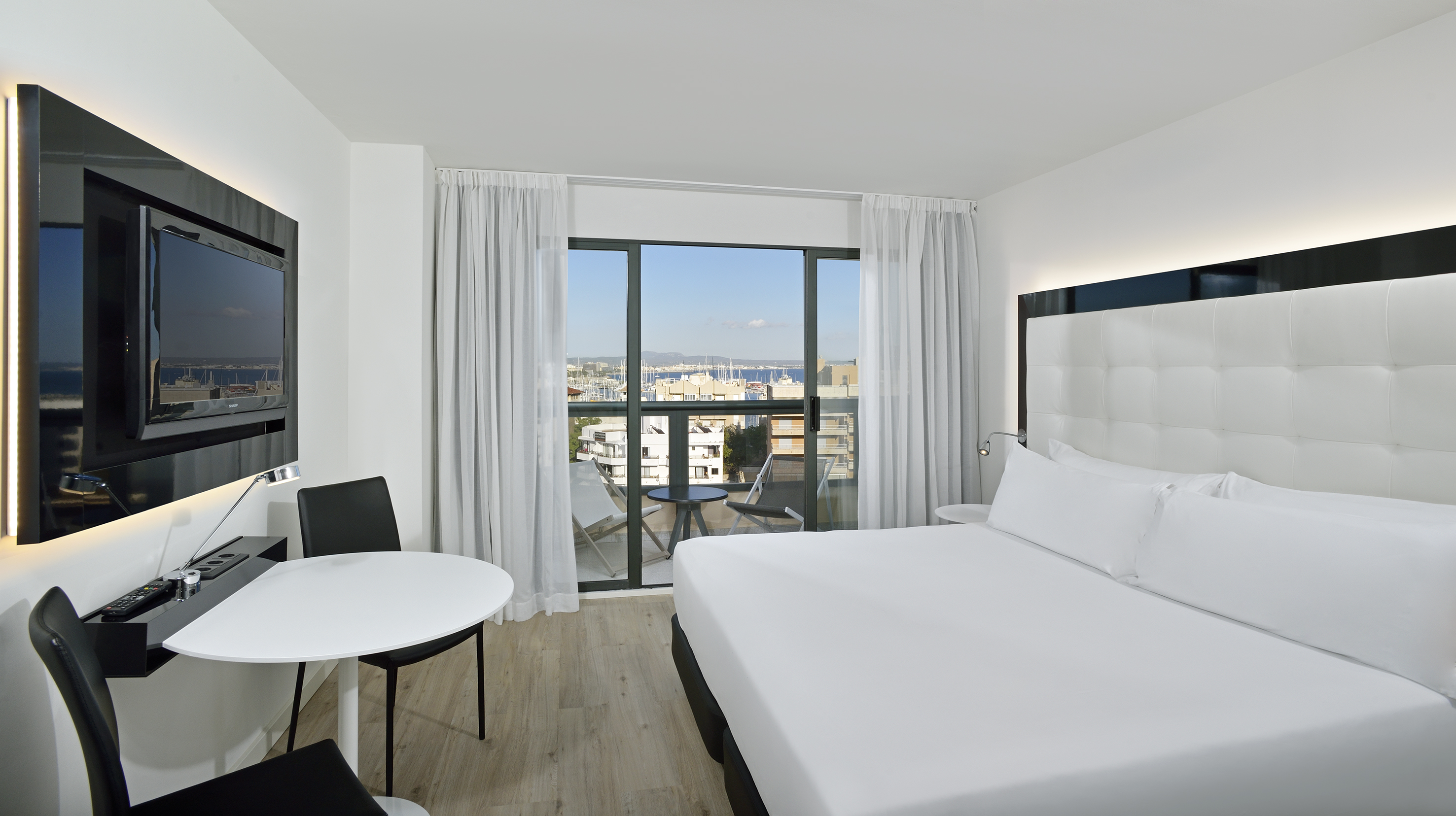 a room with a bed and a table and chairs