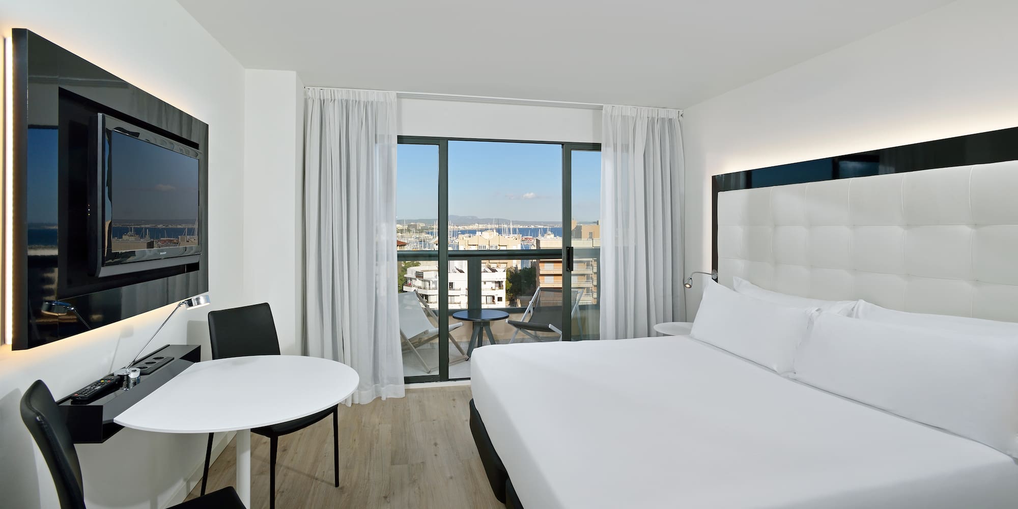 a room with a bed and a table and chairs