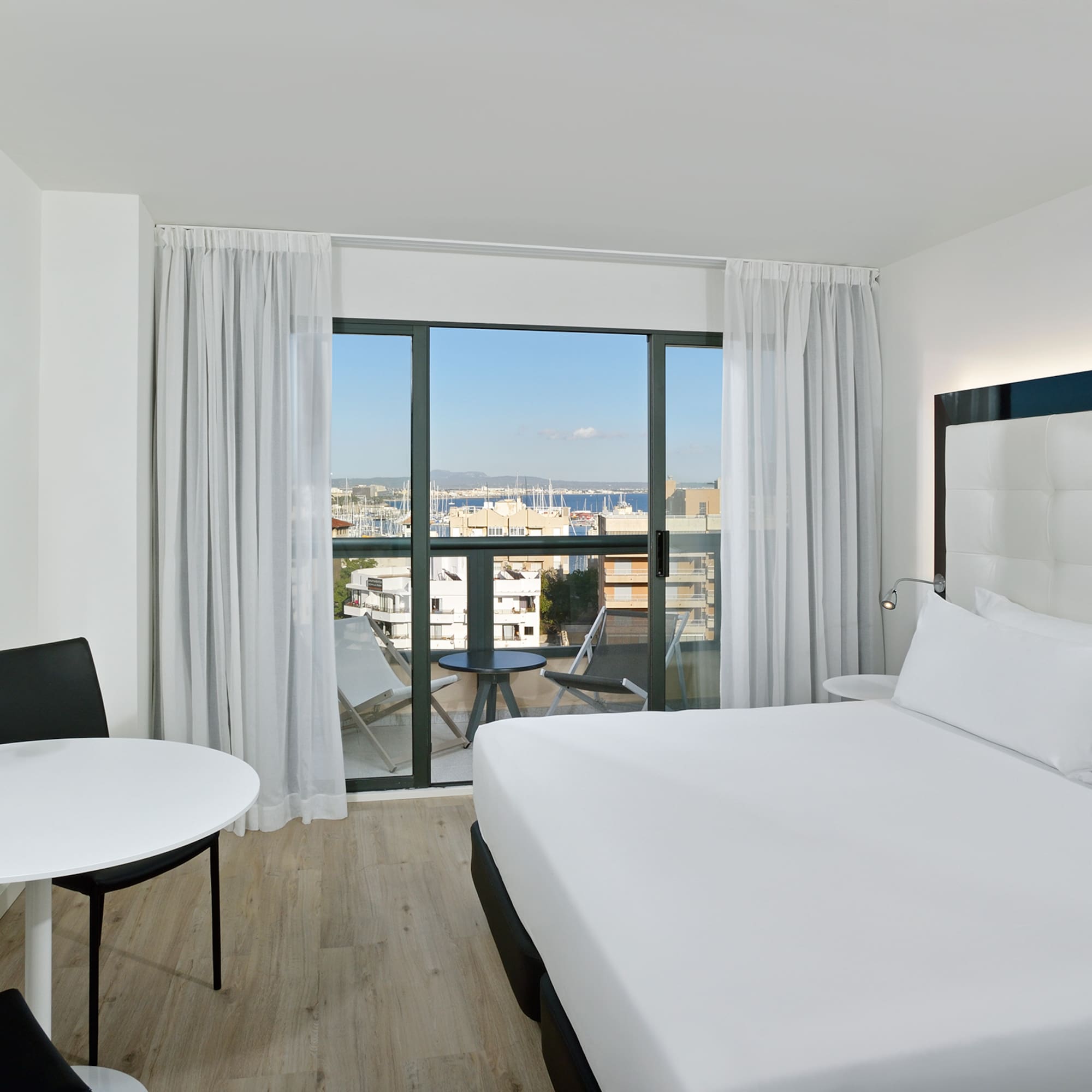 a room with a bed and a table and chairs