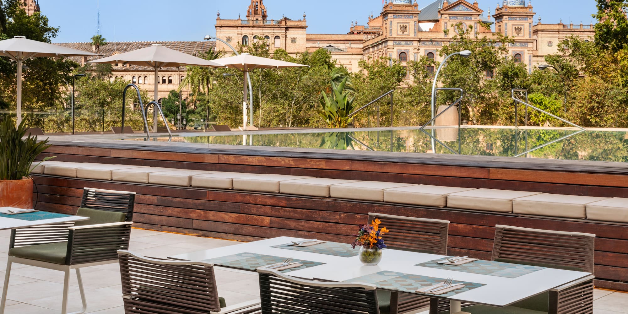 a table and chairs outside with a large building in the background