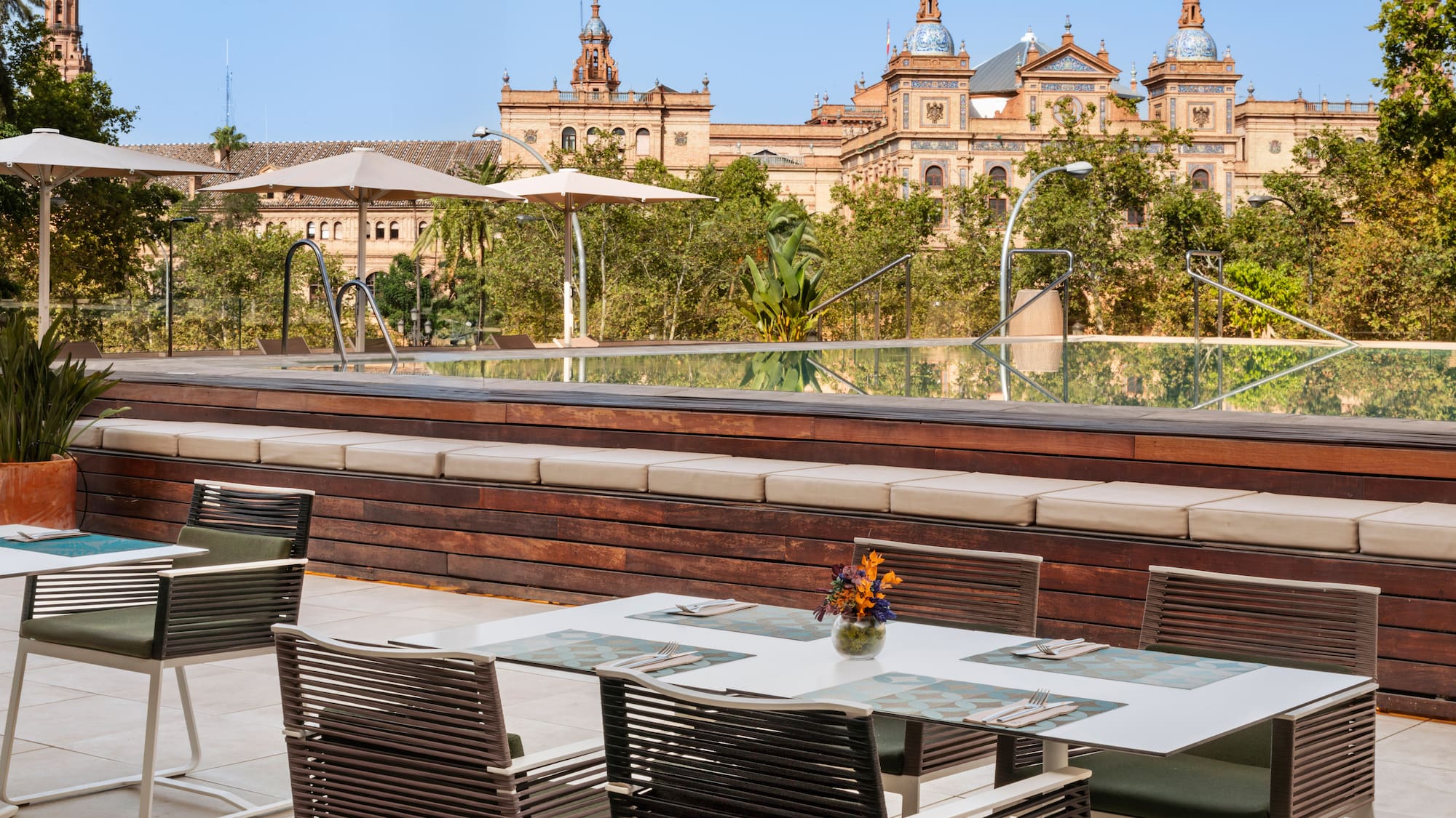 a table and chairs outside with a large building in the background