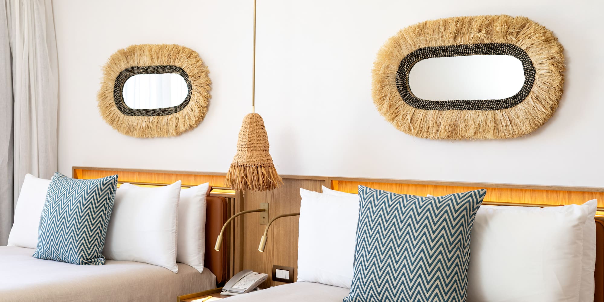 a bed with pillows and a mirror on the wall