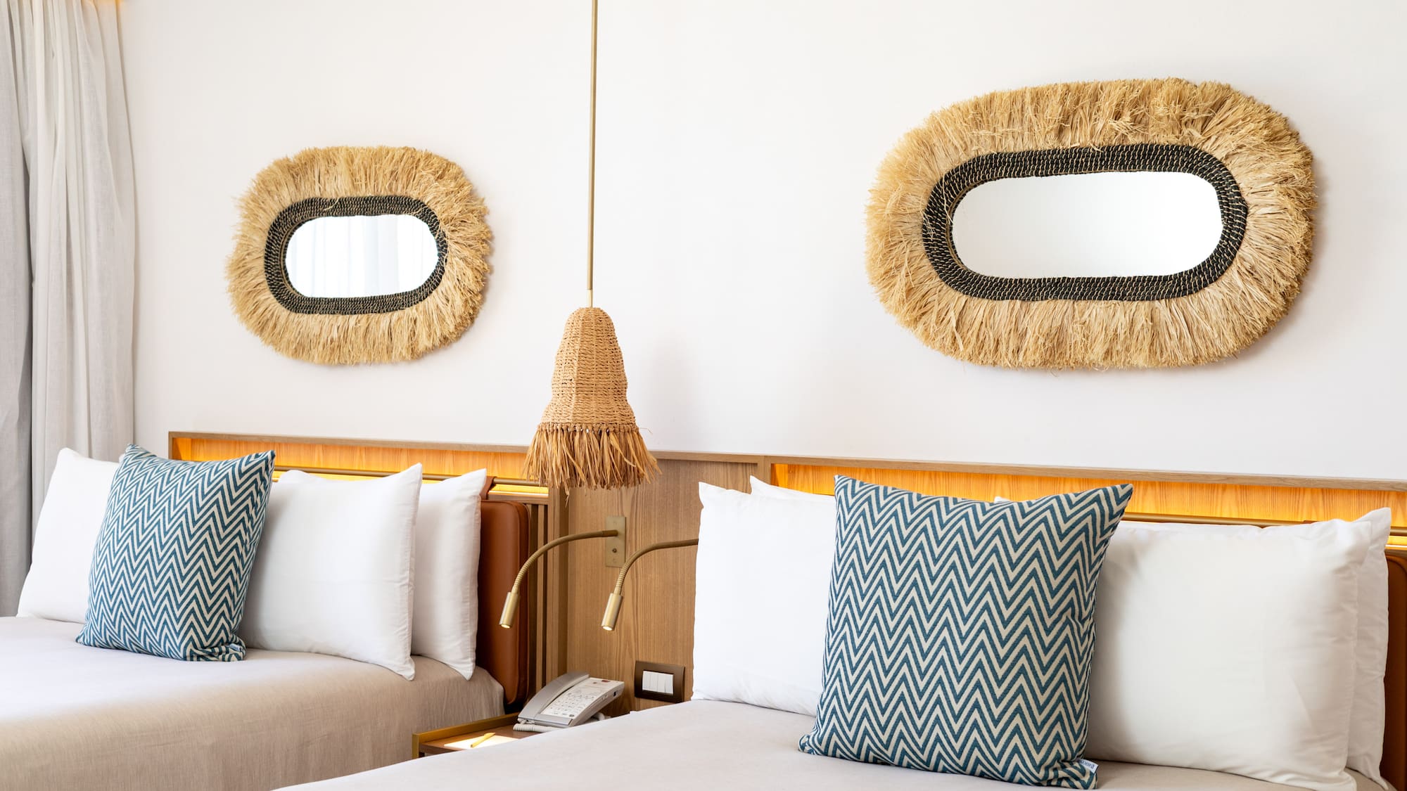 a bed with pillows and a mirror on the wall