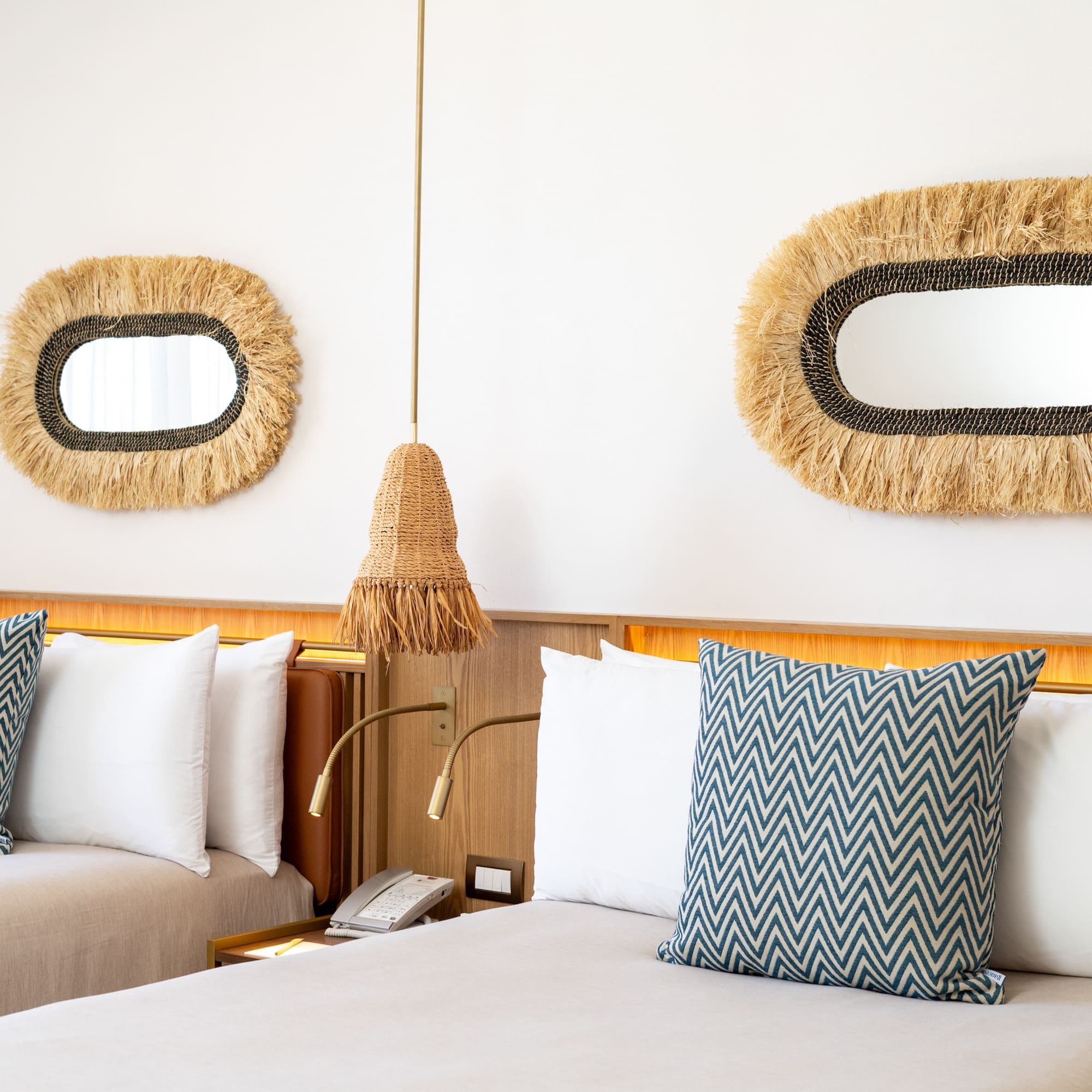 a bed with pillows and a mirror on the wall