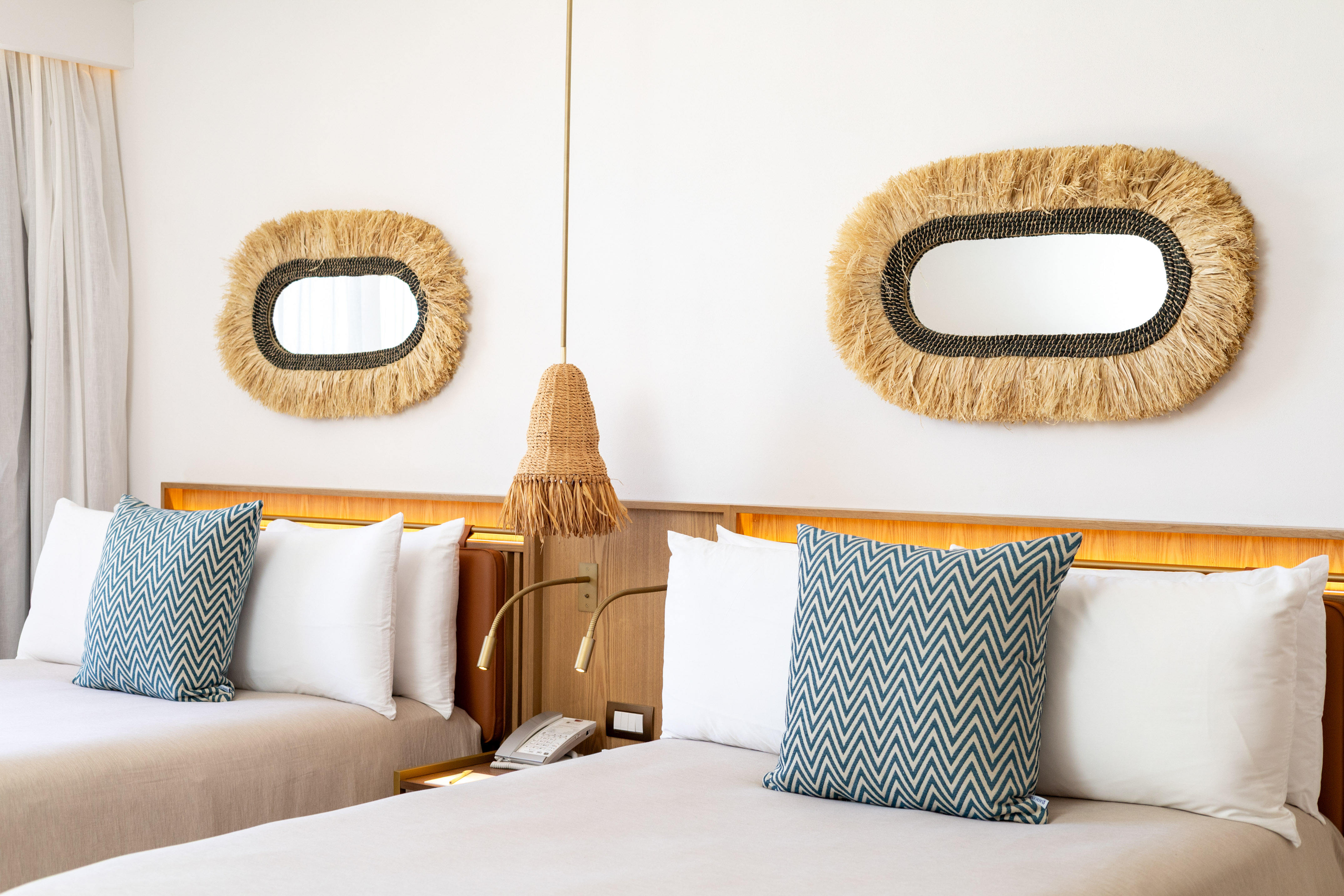 a bed with pillows and a mirror on the wall