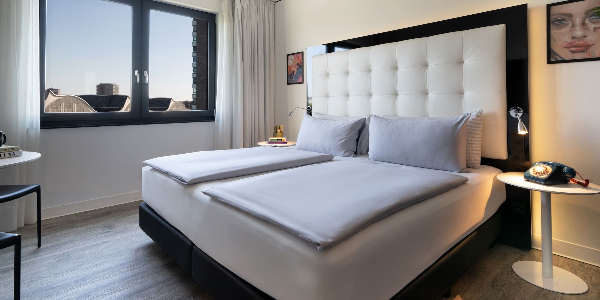 a bed with white sheets and a black headboard in a room