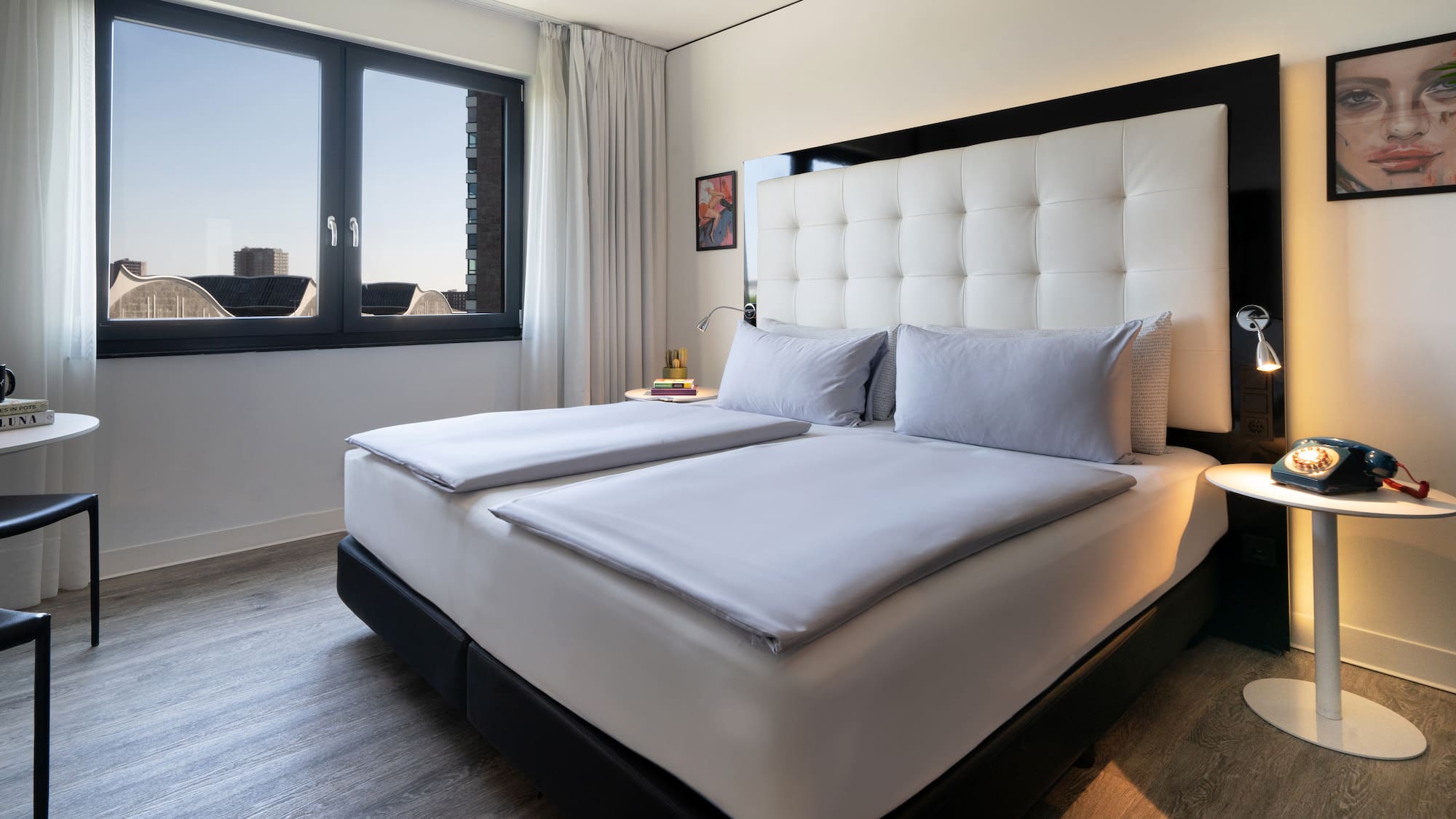 a bed with white sheets and a black headboard in a room