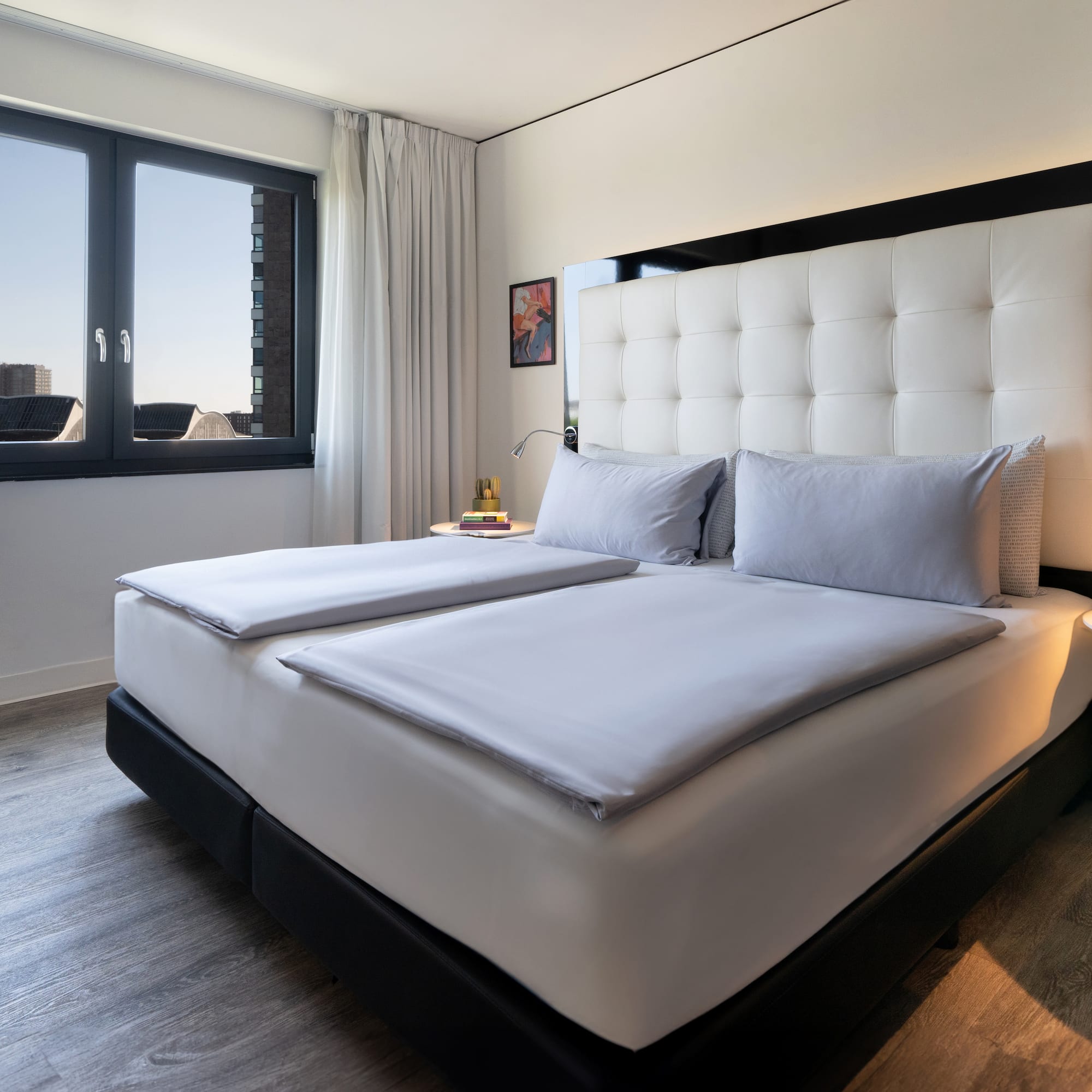 a bed with white sheets and a black headboard in a room