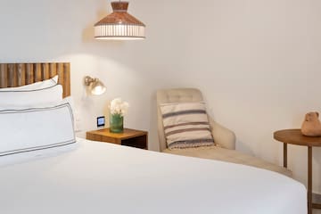 a bed with a chair and a lamp