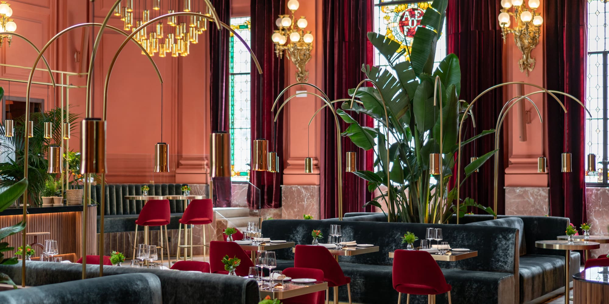 a room with tables and chairs and a large plant