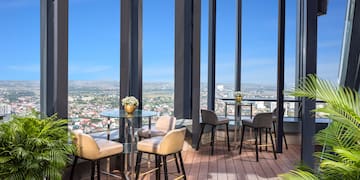 a patio with tables and chairs and a view of a city