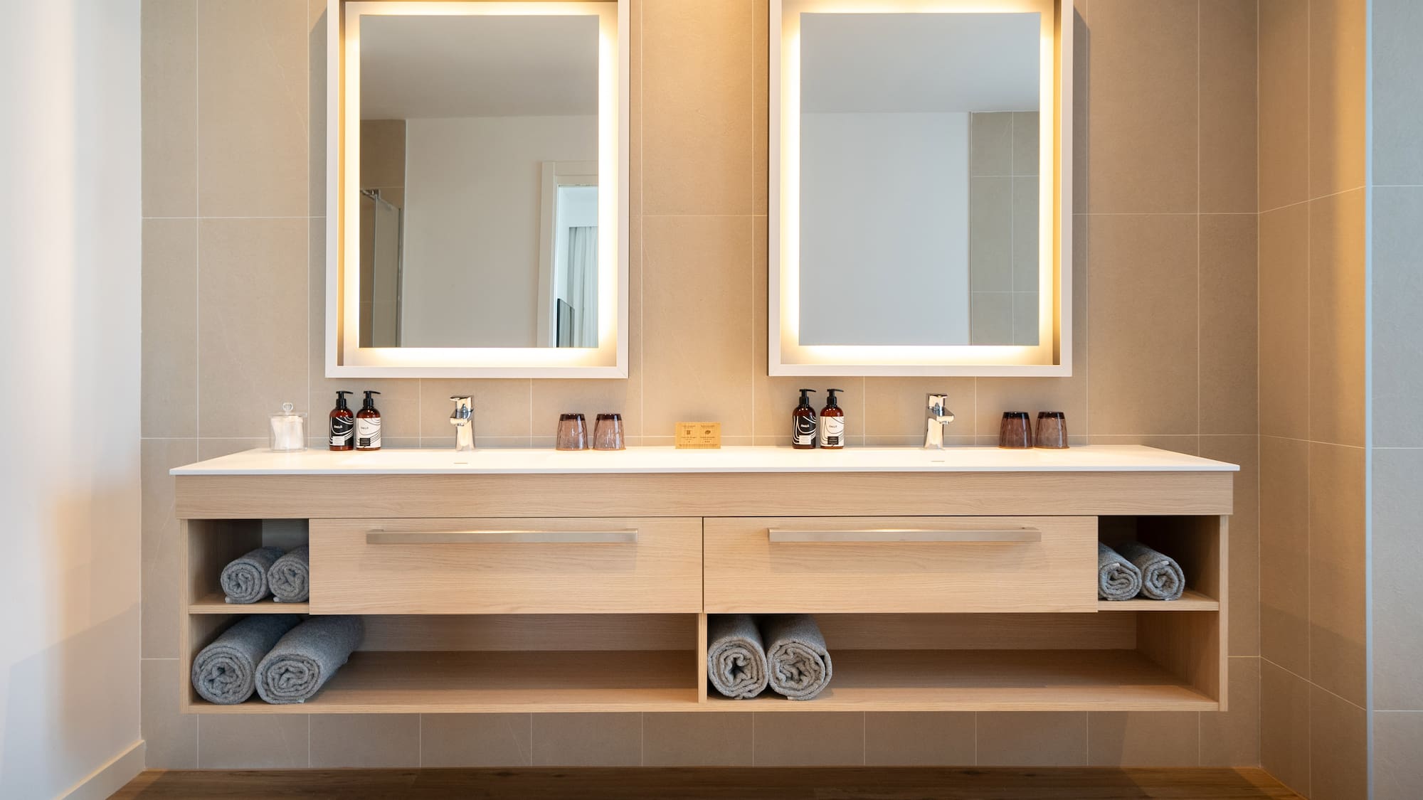 a bathroom with a double sink and two mirrors
