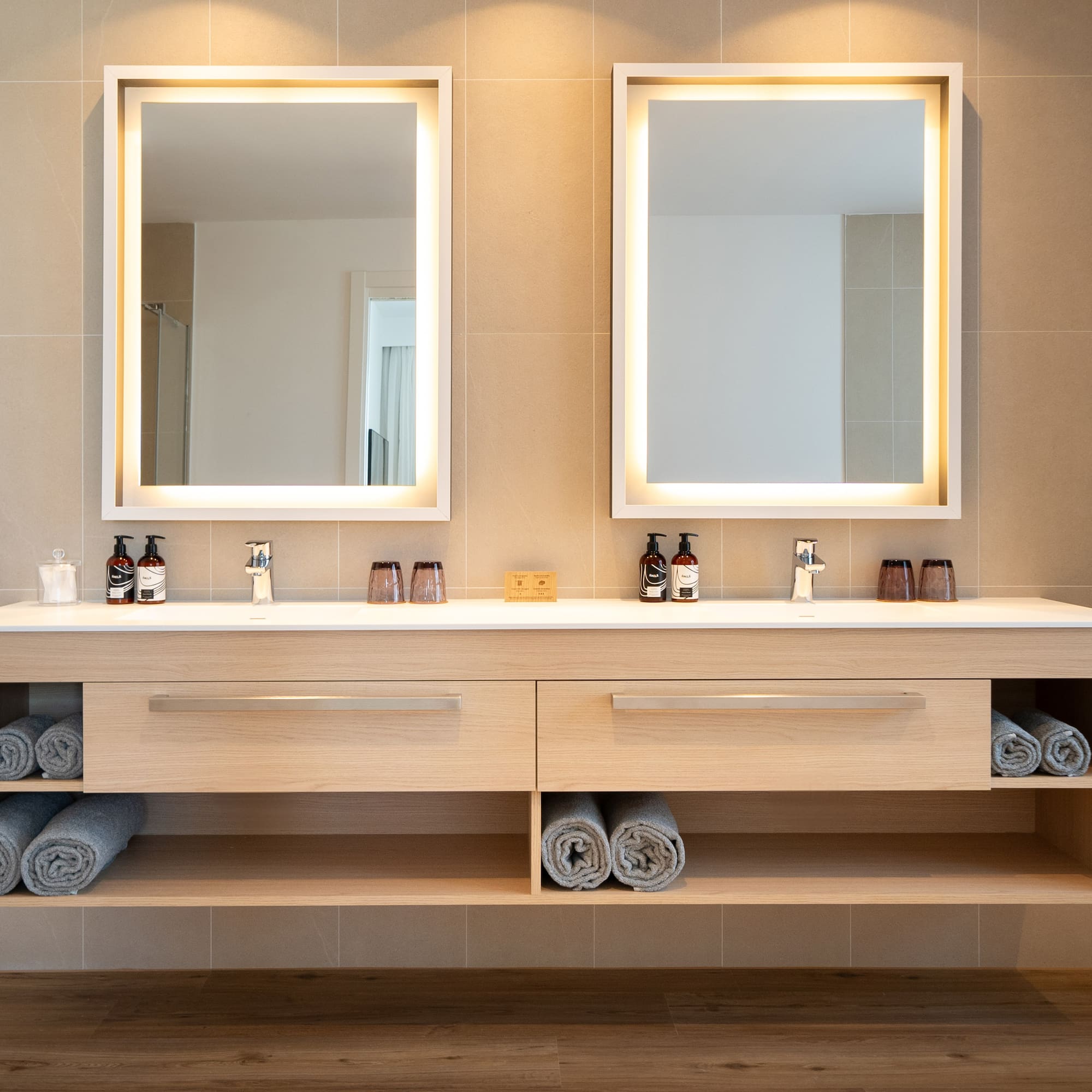 a bathroom with a double sink and two mirrors
