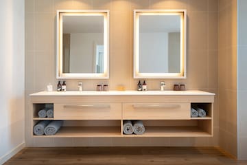 a bathroom with a double sink and two mirrors