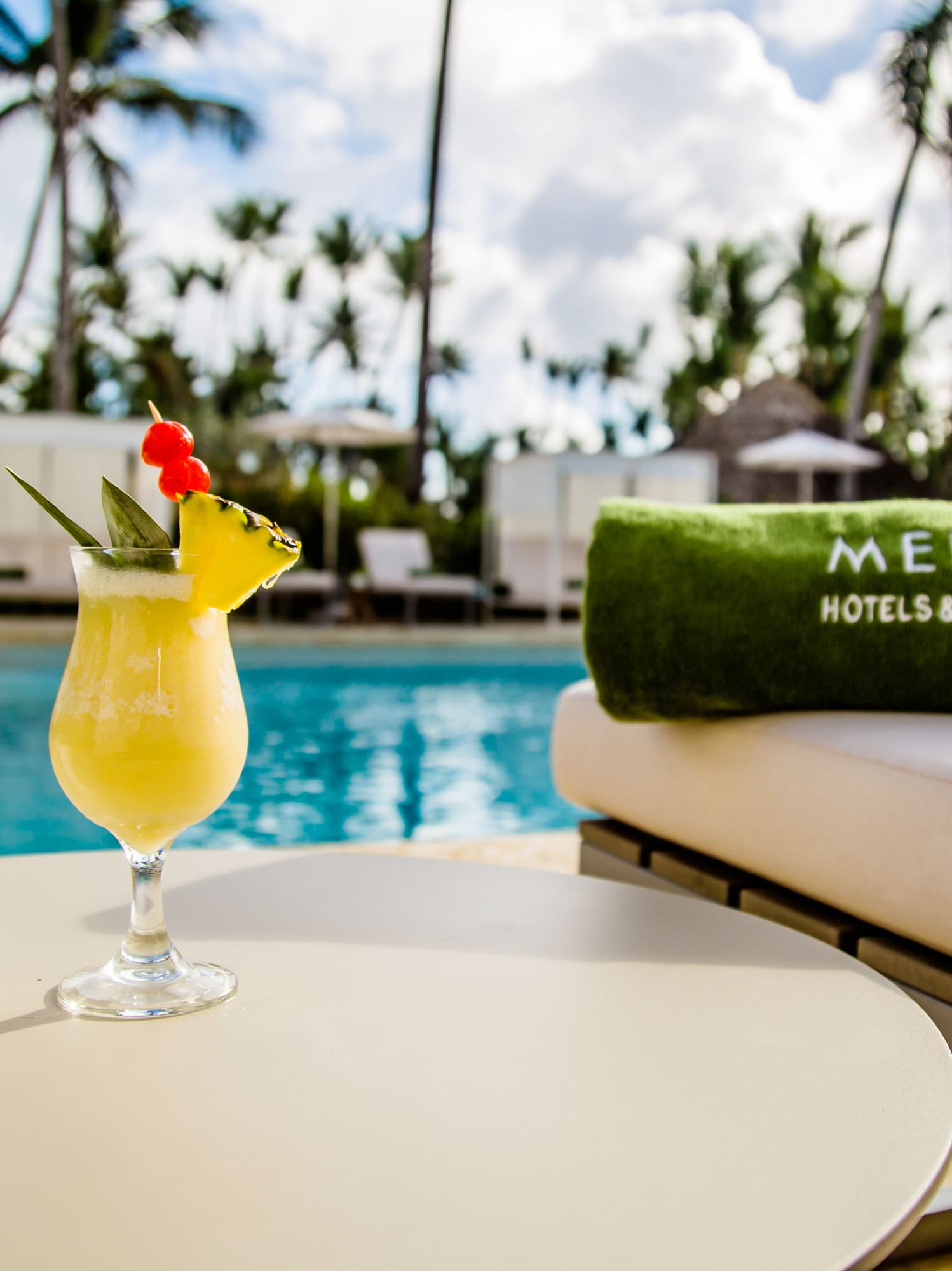 a drink on a table by a pool