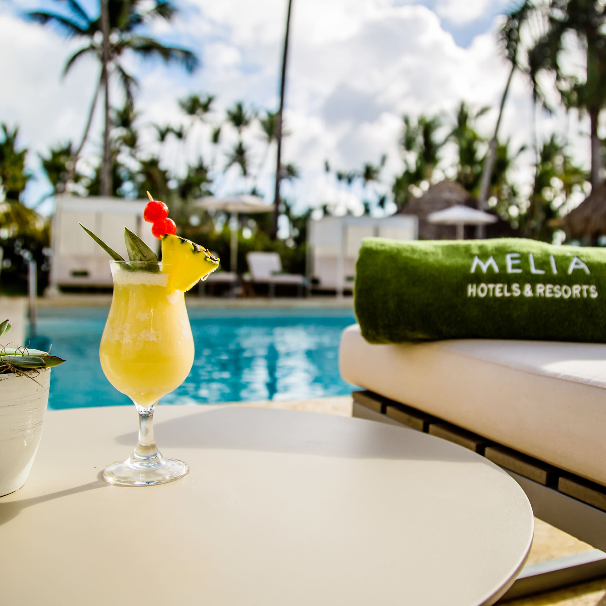 a drink on a table by a pool