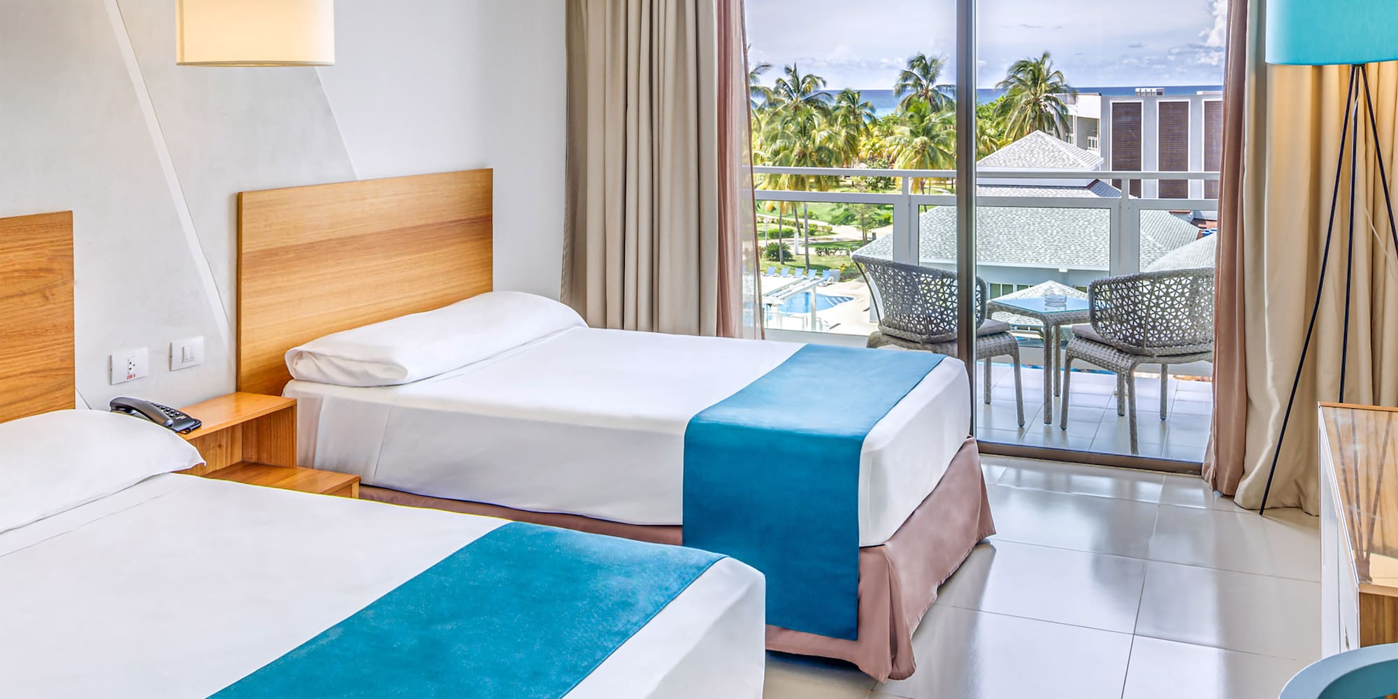 a room with two beds and a table and chairs