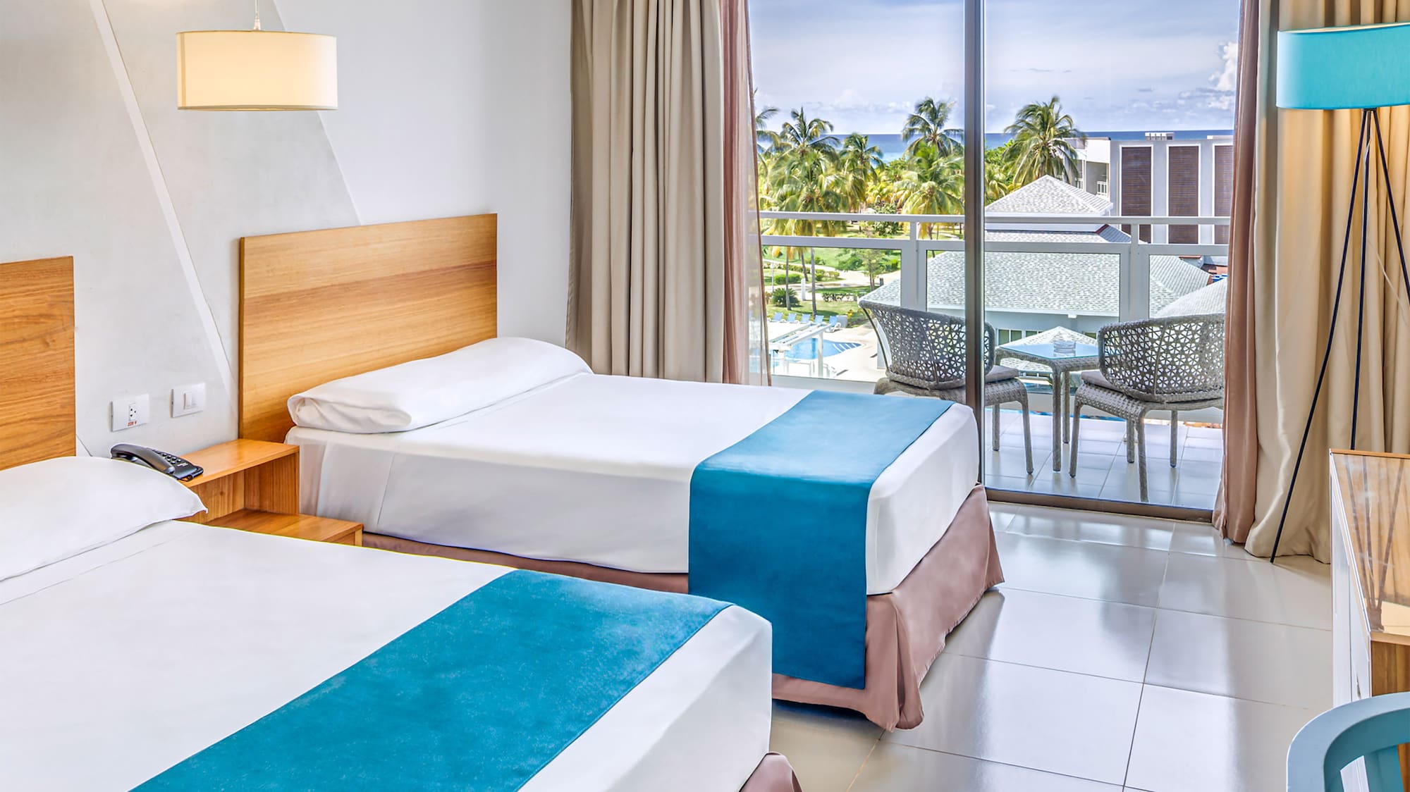 a room with two beds and a table and chairs