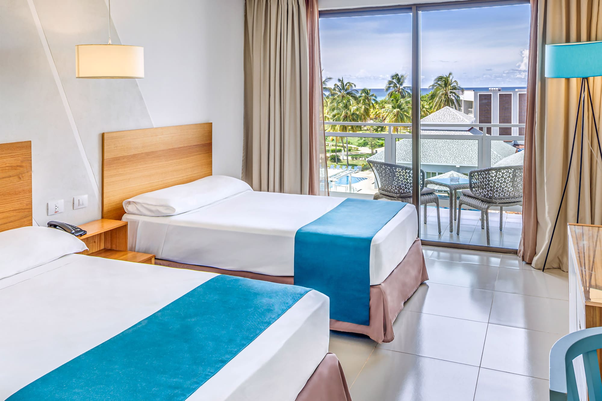 a room with two beds and a table and chairs