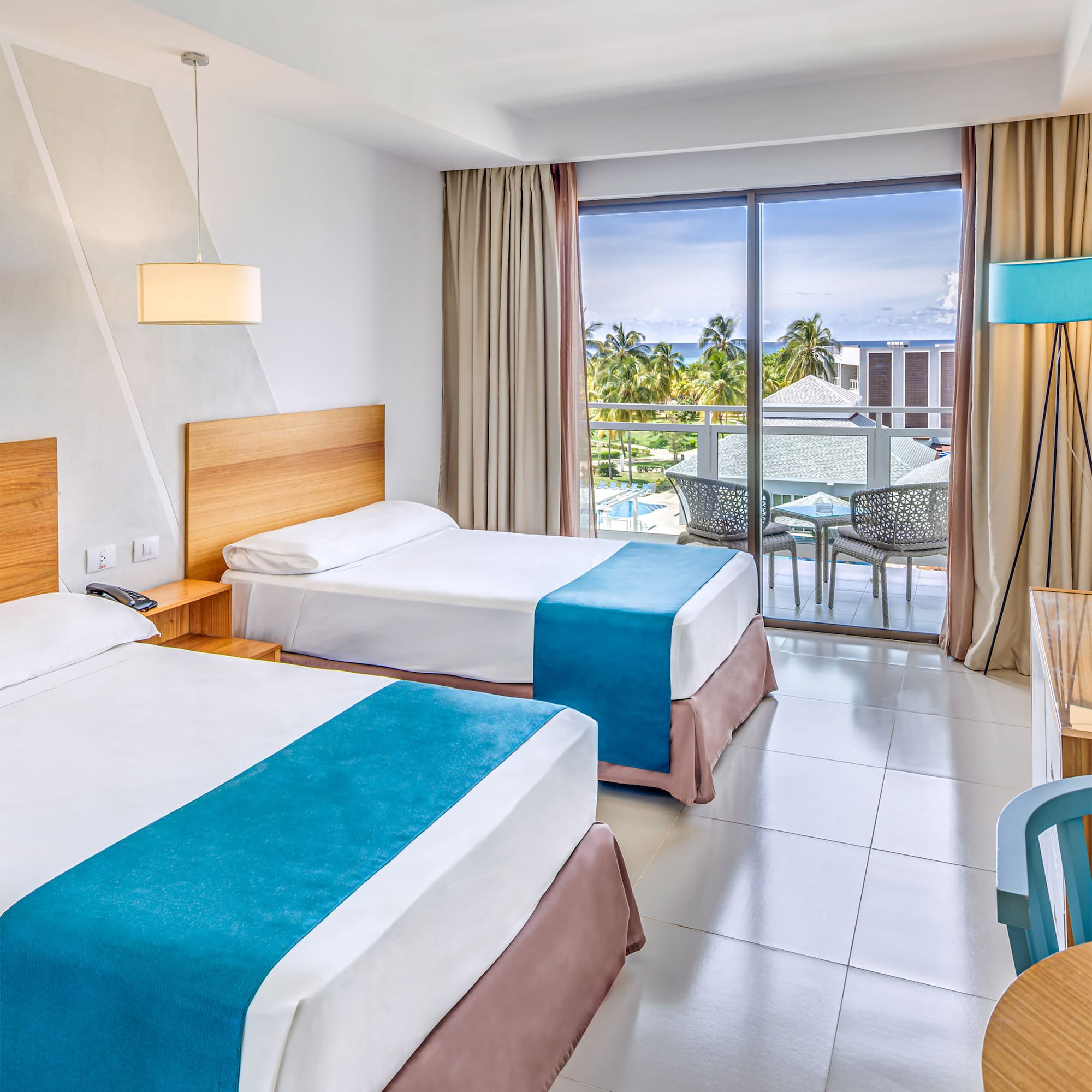 a room with two beds and a table and chairs