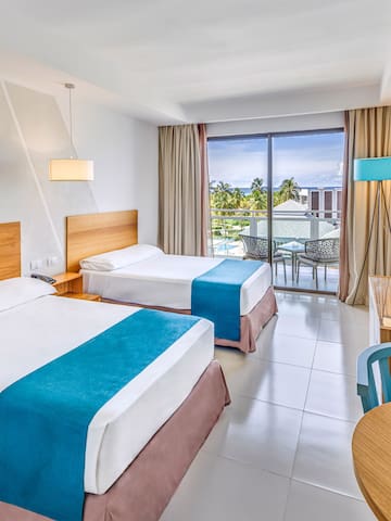 a room with two beds and a table and chairs