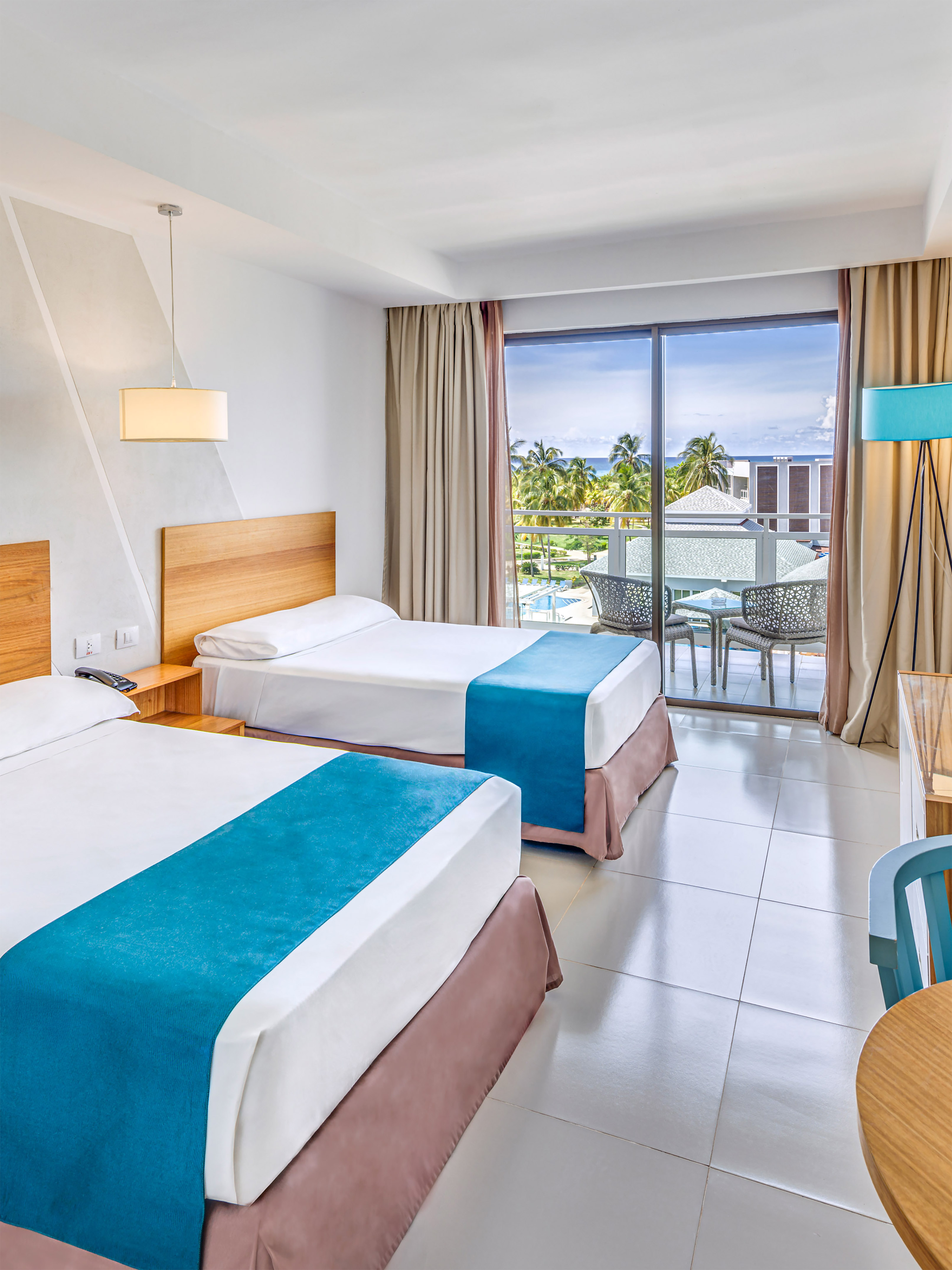 a room with two beds and a table and chairs