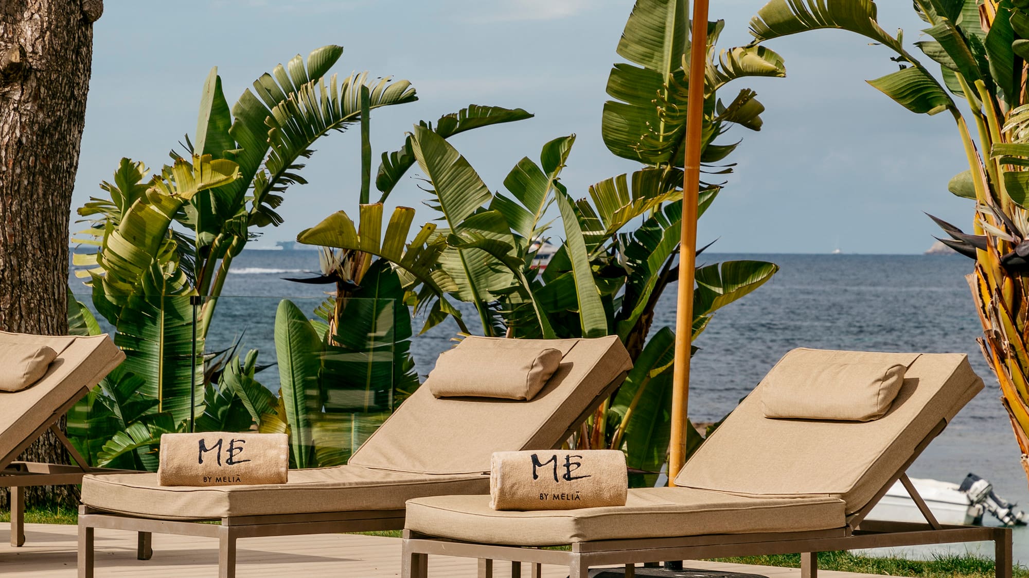 a pool with chairs and umbrella by the water