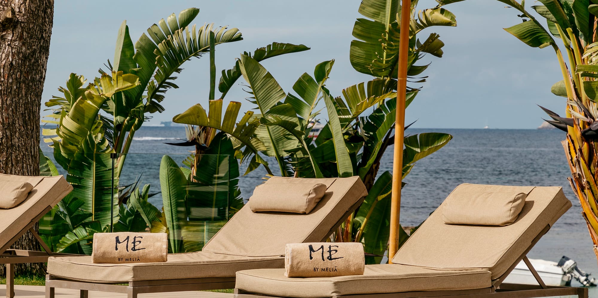 a pool with chairs and umbrella by the water