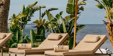 a pool with chairs and umbrella by the water