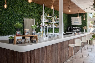 a bar with a white counter and a white chair
